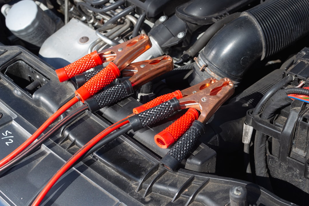 Multimeter probes on car battery terminals testing voltage - diagnose bad alternator vs dead battery