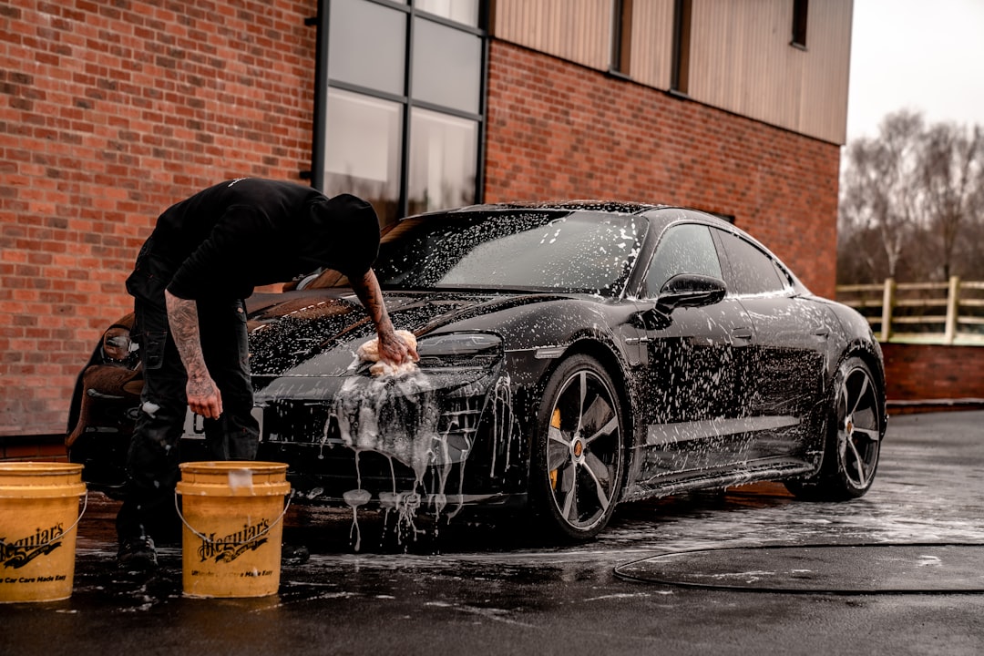Hand pulling oil dipstick from engine bay to check engine oil level - step by step guide